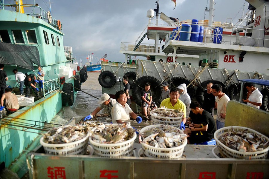 Workers unload seafood from fishing boats before super typhoon Lekima makes landfall in Zhoushan, Zhejiang province, China on August 8, 2019. Picture taken August 8, 2019 — Reuters photo