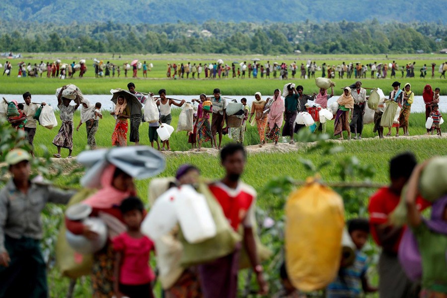 Rohingya refugees, who crossed the border from Myanmar two days before, walk after they received permission from the Bangladeshi army to continue on to the refugee camps, in Palang Khali, near Cox's Bazar, Bangladesh, October 19, 2017. Reuters/File Photo