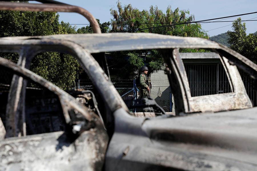 A soldier is seen near the burnt wreckage of a police patrol car after an ambush by suspected cartel on police officers in El Aguaje, in Michoacan state, Mexico on October 14, 2019 — Reuters photo