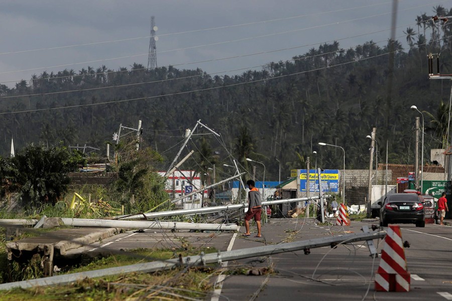A man walks past electric poles lying on the main highway after Typhoon Kammuri hit Camalig town, Philippines on December 3, 2019 — Reuters photo