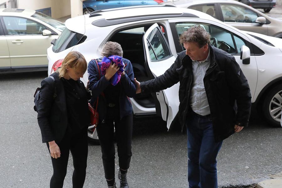 A British woman, accused of lying about being gang raped, covering her face as she arrives at the Famagusta courthouse in Paralimni, Cyprus on Monday. -Reuters Photo