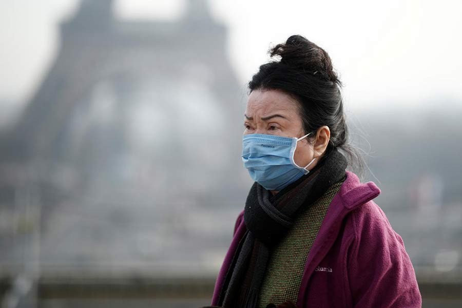 A woman wearing a face mask on the Trocadero esplanade in front of the Eiffel Tower in Paris, France, on Saturday, as France confirmed three cases of the new coronavirus. -Reuters Photo