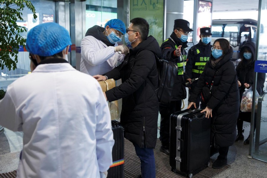A medical official takes the body temperature of a man at the departure hall of the airport in Changsha, Hunan Province, as the country is hit by an outbreak of a new coronavirus, China, January 27, 2020. Reuters