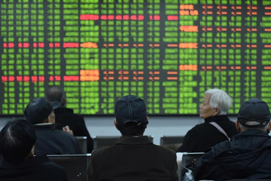 Investors sitting in front of a board showing stock information at a brokerage house on the first day of trade in China since the Lunar New Year, in Hangzhou, Zhejiang province, China this month. -Reuters Photo