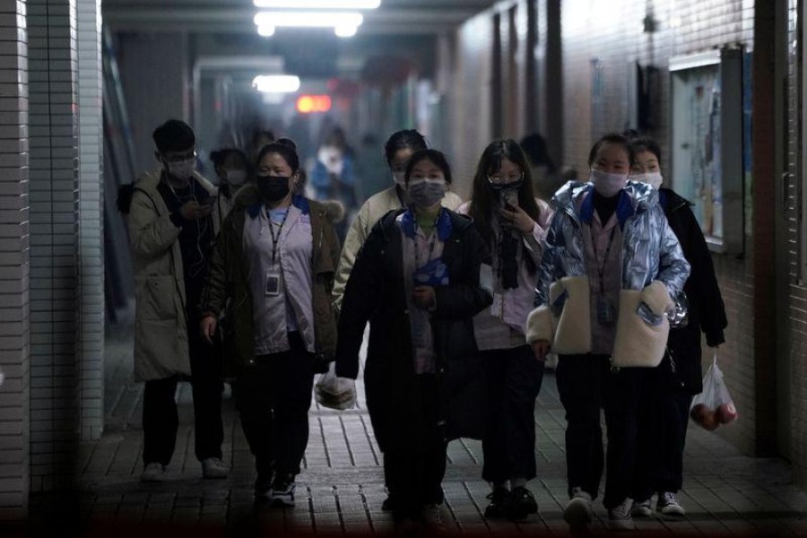 Workers wearing masks walk outside their dormitory, in an electronics manufacturing factory in Shanghai, China, as the country is hit by an outbreak of a new coronavirus, February 12, 2020. Reuters