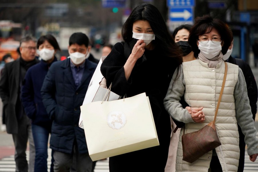 Pedestrians wearing masks to prevent contracting the coronavirus walk on a zebra crossing in Seoul, South Korea, March 12, 2020. REUTERS/Kim Hong-Ji
