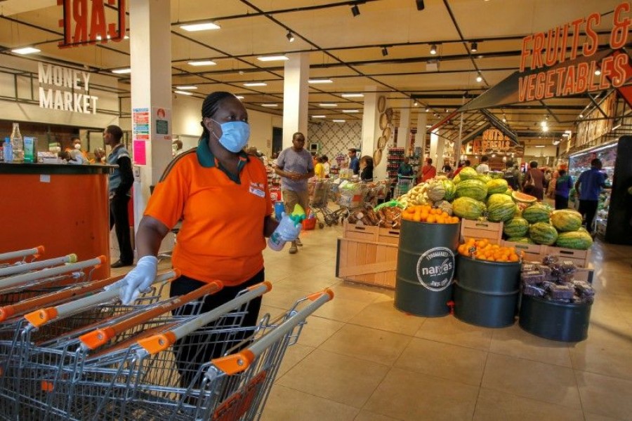 FILE PHOTO: A worker disinfects shopping trolleys as customers shop in the Naivas Supermarket, to stock their homes amid concerns about the spread of coronavirus disease (COVID-19) in Nairobi, Kenya March 23, 2020. REUTERS/Njeri Mwangi/File Photo