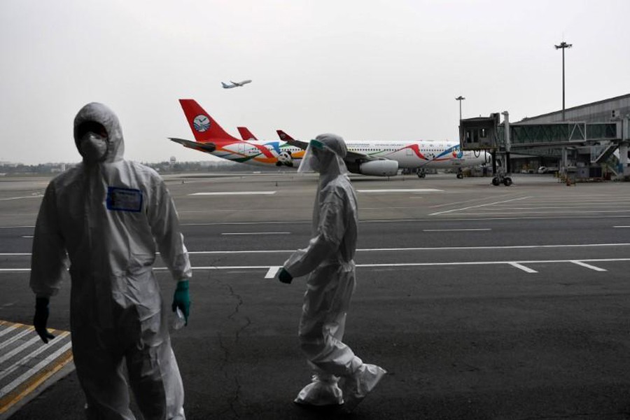 Customs officers in protective suits are seen near a Sichuan Airlines aircraft on the tarmac of Chengdu Shuangliu International Airport following a global outbreak of the coronavirus disease (COVID-19), in Chengdu, Sichuan province, China on March 26, 2020 — cnsphoto via REUTERS