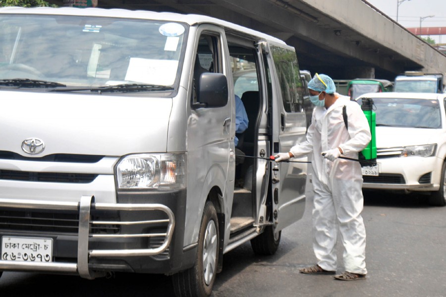 A volunteer in protective suit seen spraying disinfectants inside vehicles on the street near Tejgaon area in Dhaka as a preventive measure against the deadly coronavirus — Focus Bangla/Files