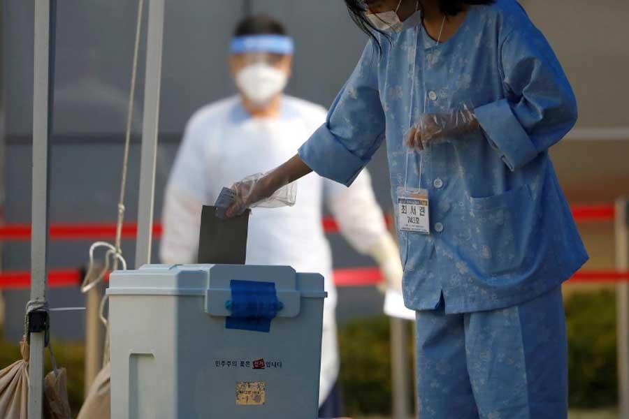 A South Korean patient affected with the coronavirus disease (COVID-19) casting her ballot for the parliamentary election at a polling station set up at a quarantine centre in Yongin, South Korea on Saturday. –Reuters Photo