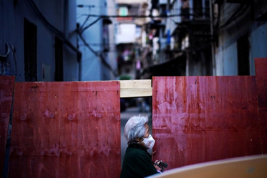 A resident wearing a face mask is seen at a blocked residential area after the lockdown was lifted in Wuhan, capital of Hubei province and China's epicentre of the novel coronavirus disease (COVID-19) outbreak, April 12, 2020. – Reuters