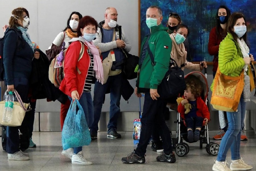 Passengers wearing protective masks arrive to collect their luggage inside an airport, following an outbreak of the coronavirus disease (COVID-19), in New Delhi, India, March 14, 2020. — Reuters