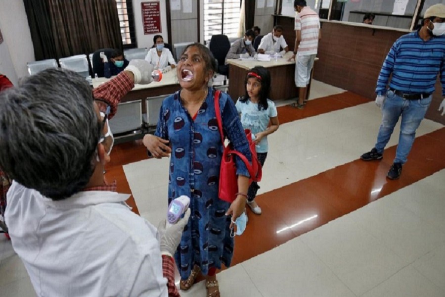 A doctor examines a woman following her arrival from Rajasthan at a government office building on the outskirts of Ahmedabad in Gujarat, April 23, 2020. — Reuters