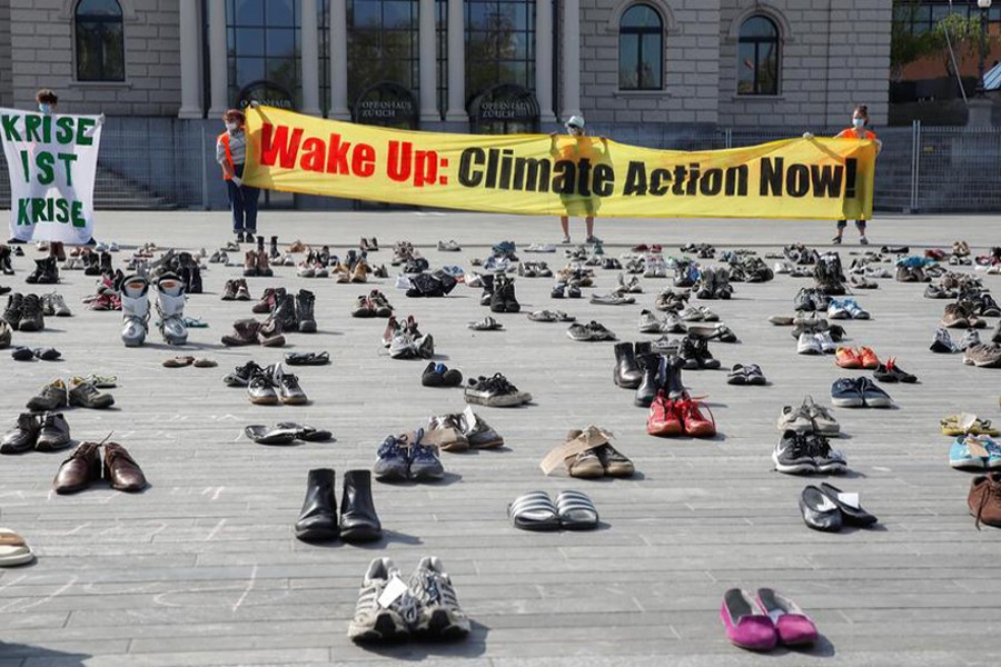 Environmental activists of Swiss Klimastreik Schweiz movement hold banners, one of them reads: "Crisis is crisis", after placing shoes in place of live participants to demonstrate against climate change, as the spread of the coronavirus disease (COVID-19) continues, in front of the opera house on the Sechselaeutenplatz square in Zurich, Switzerland on April 24, 2020 — Reuters photo