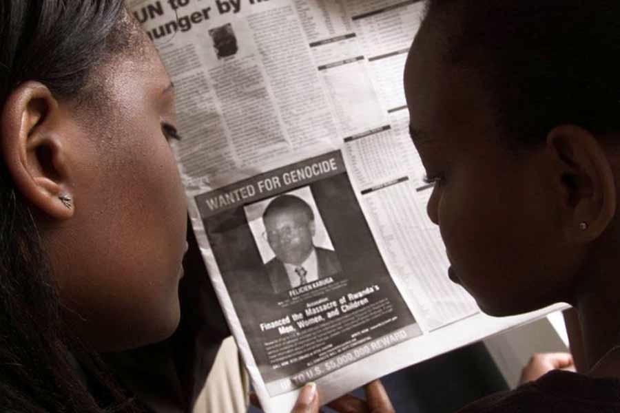 Readers looking at a newspaper June 12, 2002 in Nairobi carrying the photograph of Rwandan Felicien Kabuga wanted by the United States. The United States published a "wanted" photograph in Kenyan newspapers of the businessman accused of helping finance the 1994 killings in Rwanda. –Reuters Photo