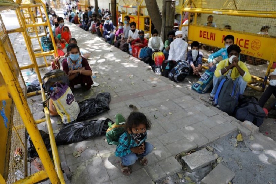 Migrant workers and their families wait to get on a bus to reach a railway station to board a train to their home state of Uttar Pradesh, during an extended lockdown to slow the spreading of the coronavirus disease (COVID-19), in New Delhi, India, May 26, 2020. — Reuters
