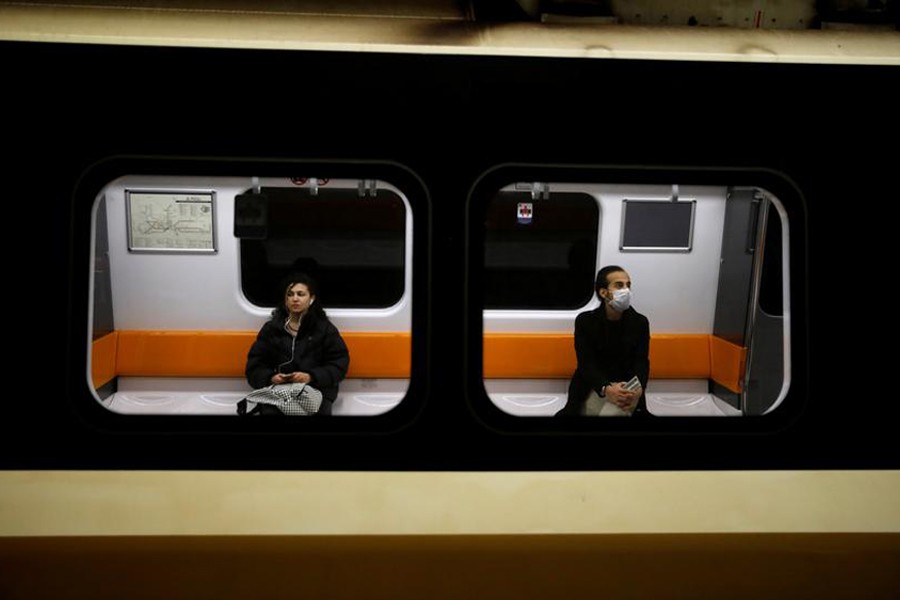 A man wearing a protective face mask and a woman are seen on a train as the spread of the coronavirus disease (COVID-19) continues in Istanbul, Turkey on March 26, 2020 — Reuters/Files