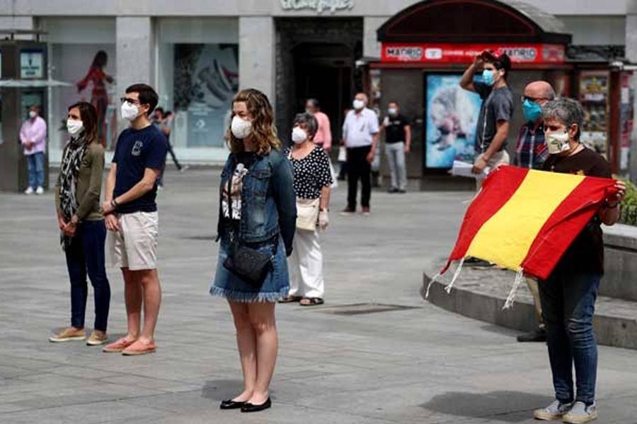People observing a daily minute of silence to commemorate victims of the coronavirus disease (COVID-19), at Puerta del Sol square in Madrid in Spain recently. –Reuters Photo