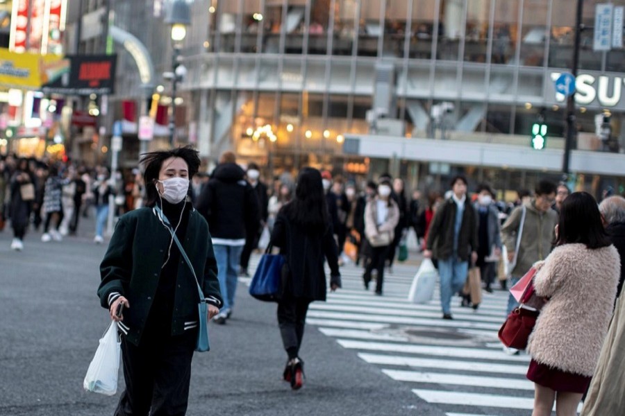 A woman wearing a protective face mask runs across a street at Shibuya in Tokyo, Japan, February 17, 2020. — Reuters/Files