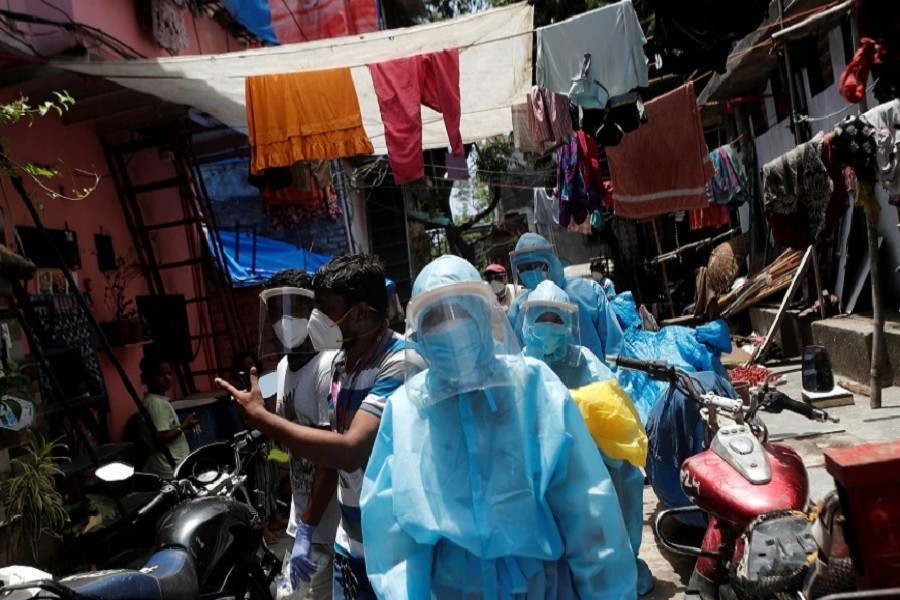 Healthcare workers wearing personal protective equipment (PPE) and volunteers walk through a slum in Dharavi, one of Asia's largest slums, to check residents during a lockdown to slow the spread of the coronavirus disease (COVID-19), in Mumbai, India, June 07, 2020. — Reuters/Files