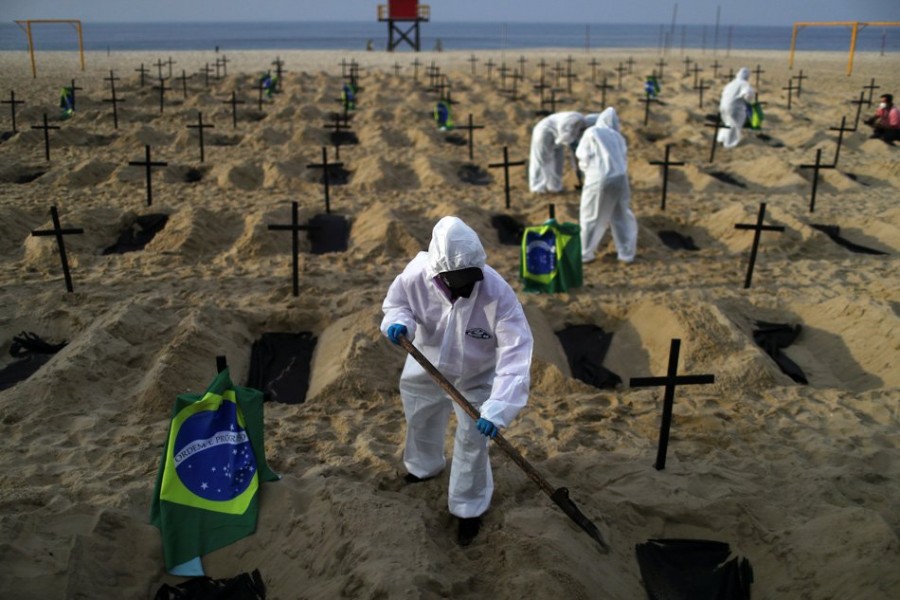 Activists of the NGO Rio de Paz wear protective gear to dig graves on Copacabana beach to symbolize the dead from coronavirus during a demonstration in Rio de Janeiro, Brazil — Reuters/Files