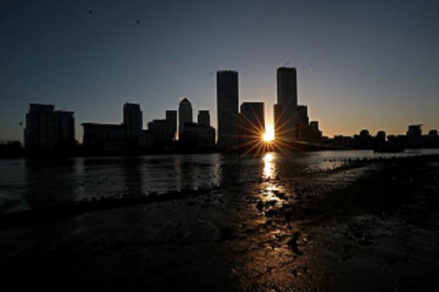 The sun rises behind the Canary Wharf financial district in London, Britain, February 12, 2020 — Reuters/Files