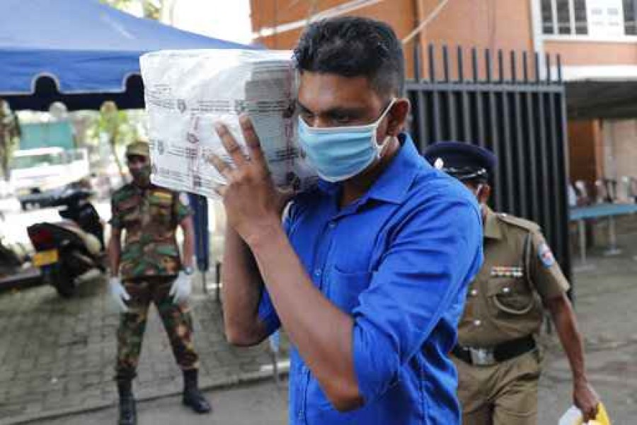 A Sri Lankan polling officer carries election material to dispatch them to polling centers ahead of the parliamentary elections in Colombo, Sri Lanka, Tuesday, Aug. 4, 2020 - AP
