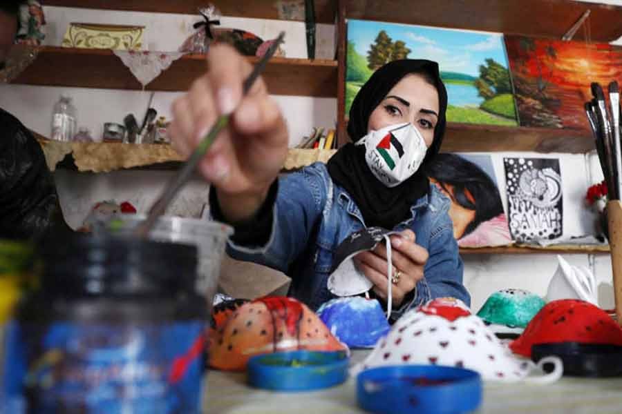 A Palestinian artist paints protective face masks to encourage people to wear them as a precaution against the coronavirus disease (COVID-19), in Gaza City      —Reuters Photo