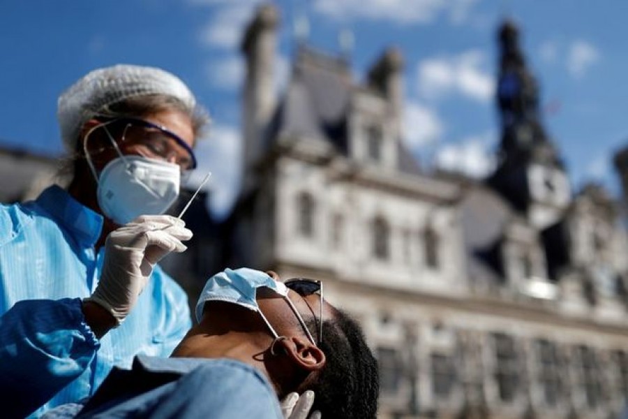 A health worker, wearing a protective suit and a face mask, prepares to administer a nasal swab to a patient at a testing site for the coronavirus disease (COVID-19) installed in front of the city hall in Paris, France, September 2, 2020. REUTERS/Christian Hartmann/File Photo