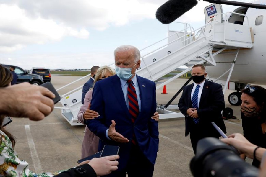 Democratic US presidential nominee Joe Biden receives a nudge from his wife, Dr Jill Biden, to remind him about proper social distancing as he speaks to reporters at Miami International Airport prior to participating in a town hall event in Miami, Florida, US on October 5, 2020 — Reuters photo