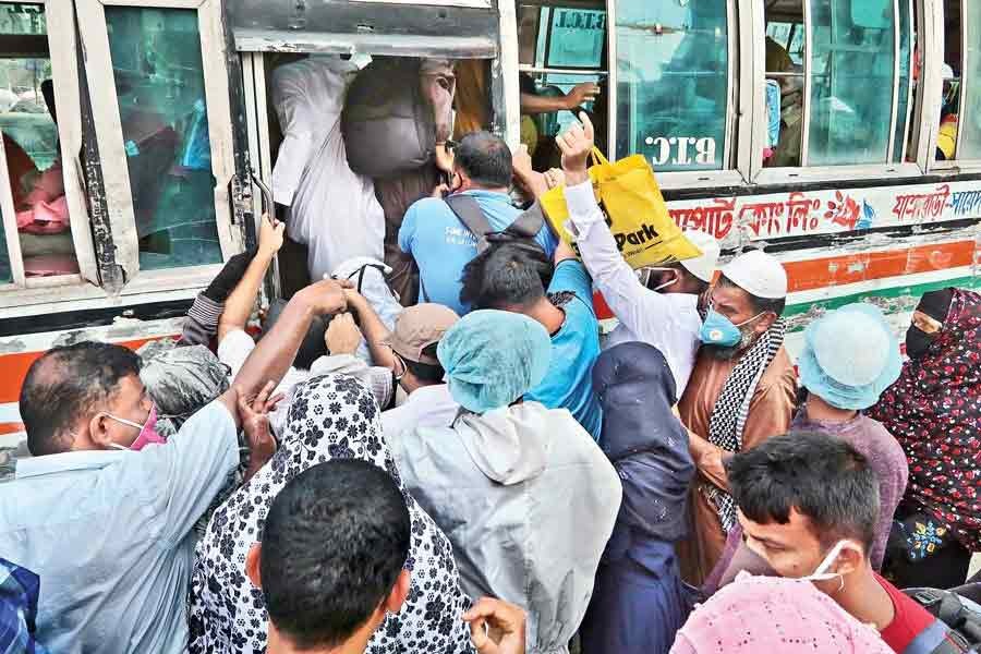 Ignoring health safety norms amid coronavirus outbreak, passengers scramble to get on a local bus in the city after resumption of bus services after over two-month shutdown during coronavirus outbreak —FE file photo