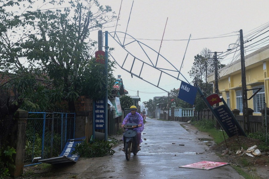 A man bikes past a broken sign as the Typhoon Molave lashes Vietnam's coast in Binh Chau village, Quang Ngai province October 28, 2020. REUTERS/Thanh Hue