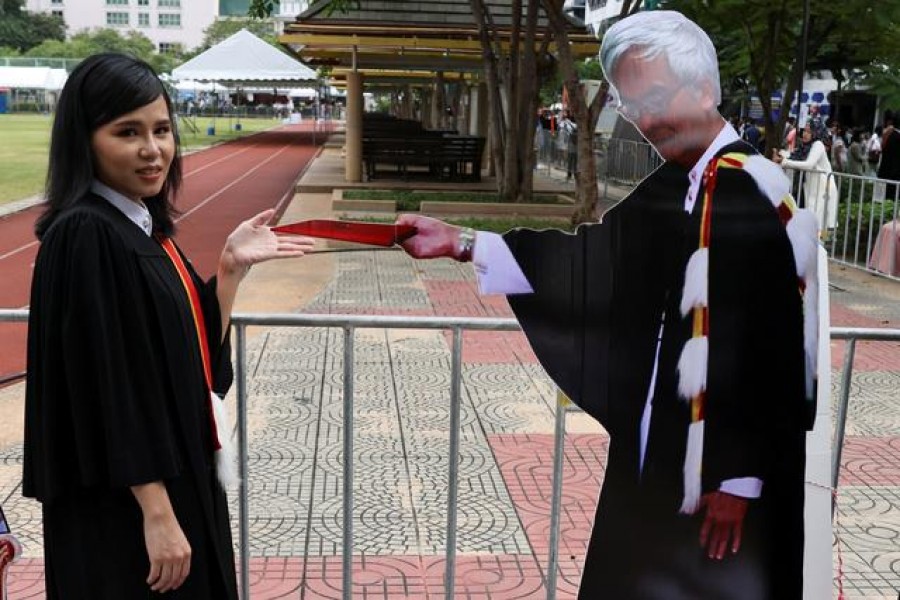A student stands next to a cardboard figure of Somsak Jeamteerasakul, an exiled Thai academic, before a graduation ceremony, which some students have boycotted because it is led by King Maha Vajiralongkorn, at Thammasat University in Bangkok, Thailand, October 31, 2020 -- Reuters