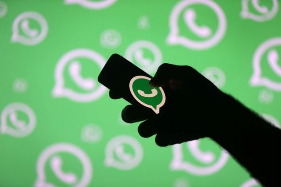 A man poses with a smartphone in front of displayed Whatsapp logo in this illustration on September 14, 2017 — Reuters/Files