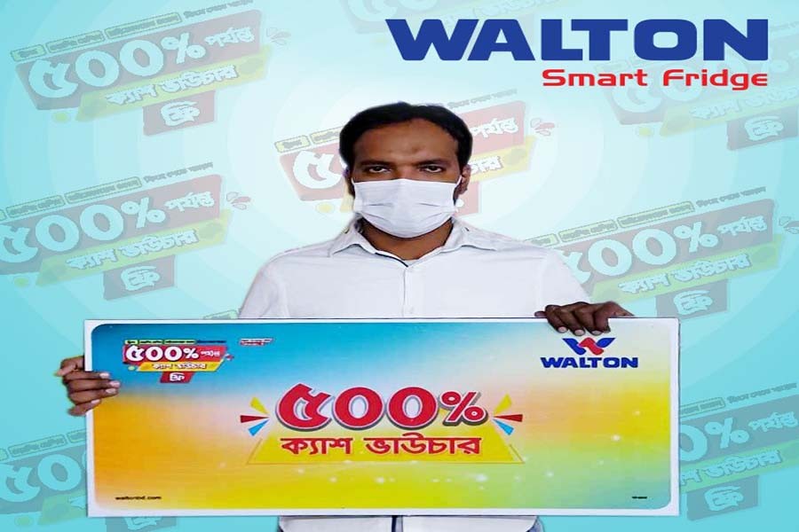 Kazi Inramul Haque, on behalf of his brother Adnan Niaz who got a cash voucher worth 500 per cent of the value of refrigerator he had purchased, officially receives the cash voucher at Walton Plaza Goalchamot branch on Thursday (November 05, 2020)