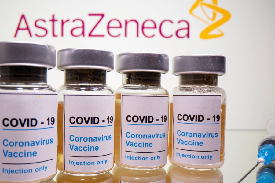 Vials with a sticker reading, "COVID-19 / Coronavirus vaccine / Injection only" and a medical syringe are seen in front of a displayed AstraZeneca logo in this illustration taken October 31, 2020. REUTERS/Dado Ruvic