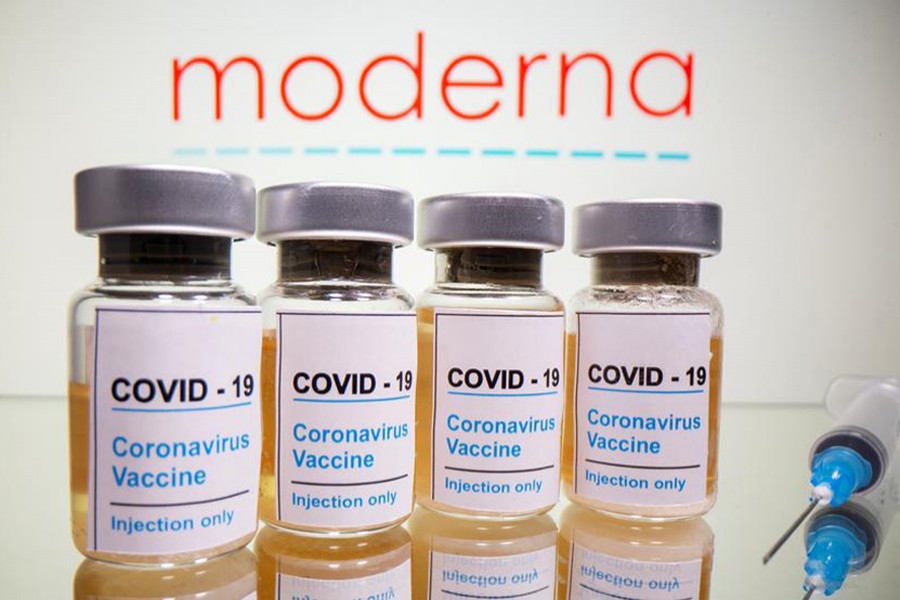 Vials with a sticker reading, "COVID-19 / Coronavirus vaccine / Injection only" and a medical syringe are seen in front of a displayed Moderna logo in this illustration taken on October 31, 2020 — Reuters/Files