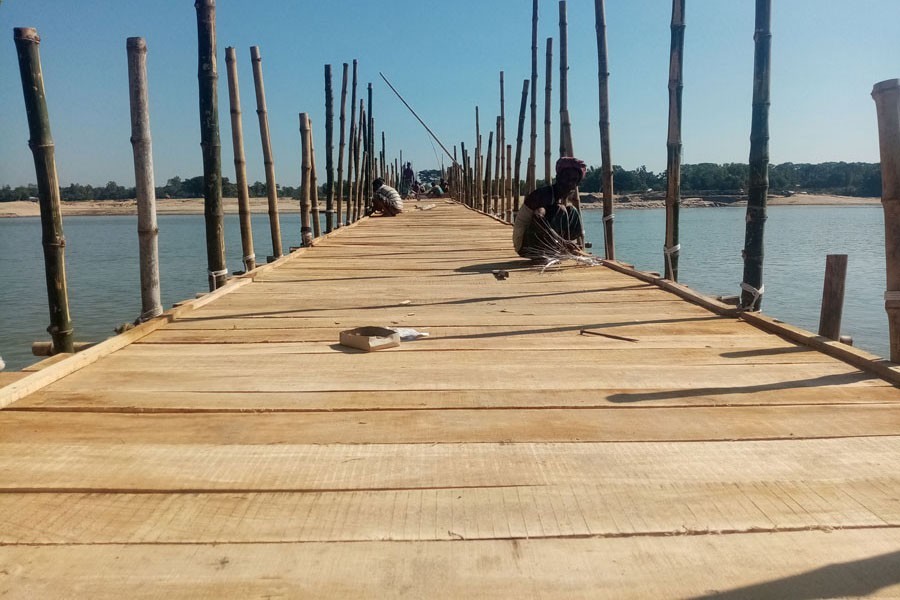 The under-construction wooden bridge on the Sumeshwari river in Birishiri point in Durgapur Upazila of Netrakona — FE Photo