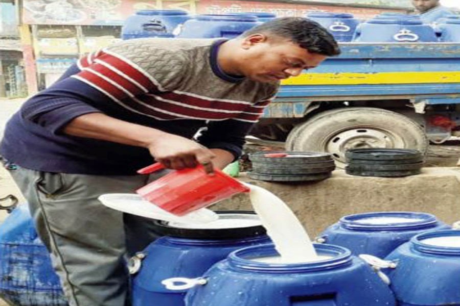 A milk trader pouring his milk into a drum at Bagmara Bazar in Cumilla's Lalmai on Tuesday — FE Photo