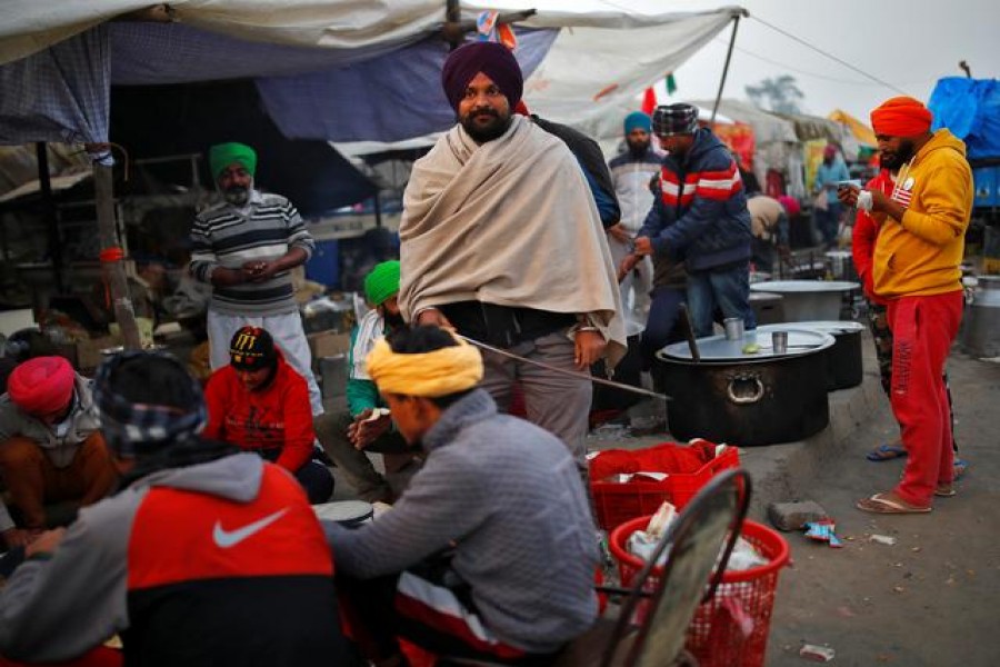 Ammy Gill, a 25-year-old lyricist from Punjab, helps to prepare "chapatis" (Indian bread) at a "Langar" or a community kitchen, at the site of a protest against new farm laws at Singhu border, near Delhi, India, December 15, 2020. REUTERS/Adnan Abidi