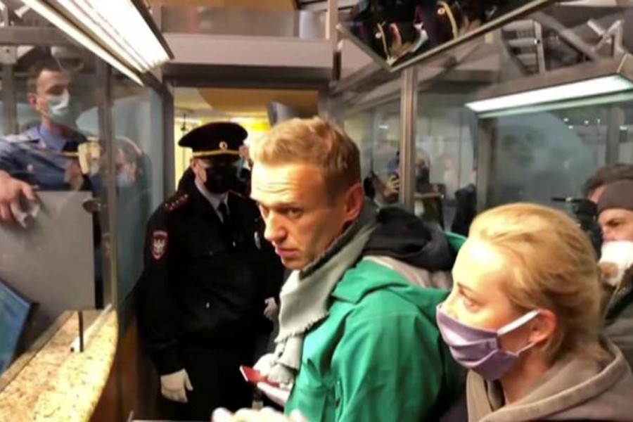 A still image taken from video footage shows law enforcement officers speaking with Russian opposition leader Alexei Navalny before leading him away at Sheremetyevo airport in Moscow, Russia on January 17, 2021 — Reuters photo
