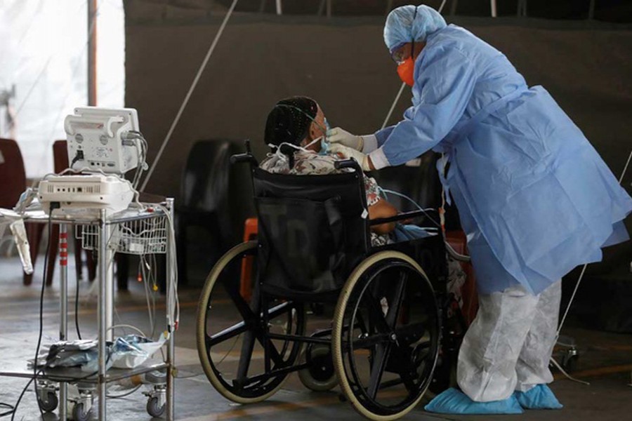 Healthcare workers tend to a patient at a temporary ward set up during the coronavirus disease (COVID-19) outbreak, at Steve Biko Academic Hospital in Pretoria, South Africa, Jan 19, 2021. REUTERS