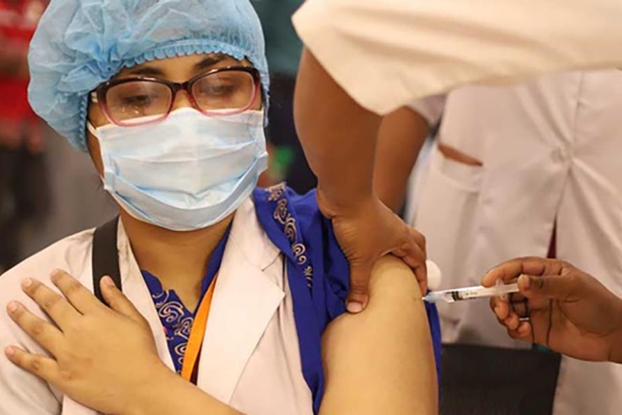 Dr Ainun Nahar Rabeya Diba, a physician of BSMMU, receives a COVID-19 vaccine shot at the hospital on Jan 28, 2021. Photo: Asif Mahmud Ove/bdnews24.com