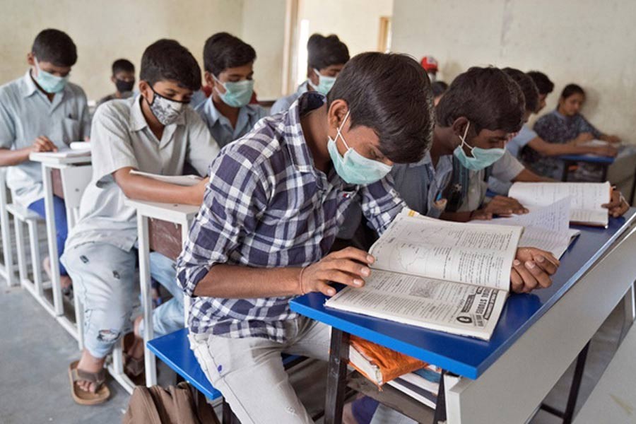 Students wearing protective masks attend a class in a government-run school in Hyderabad, India, March 5, 2020. Reuters