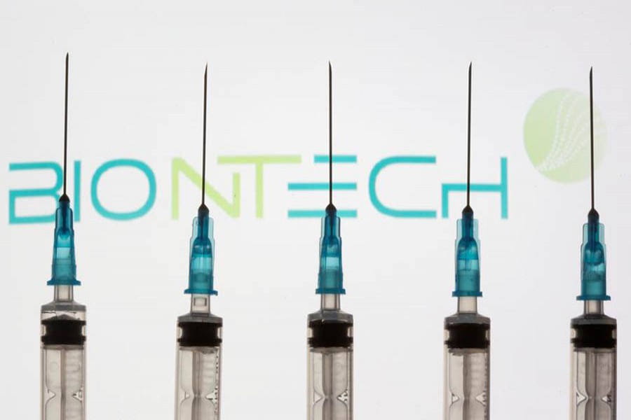 Syringes are seen in front of a displayed Biontech logo in this illustration taken November 10, 2020 — Reuters/Illustration