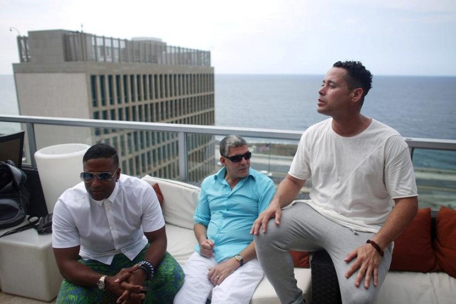 FILE PHOTO: (L-R) Members of the Cuban fusion group Orishas - Yotuel, Roldan and Ruzzo - give an interview from the top of a building in Havana, Cuba, June 22, 2016. REUTERS/Alexandre Meneghini/File Photo
