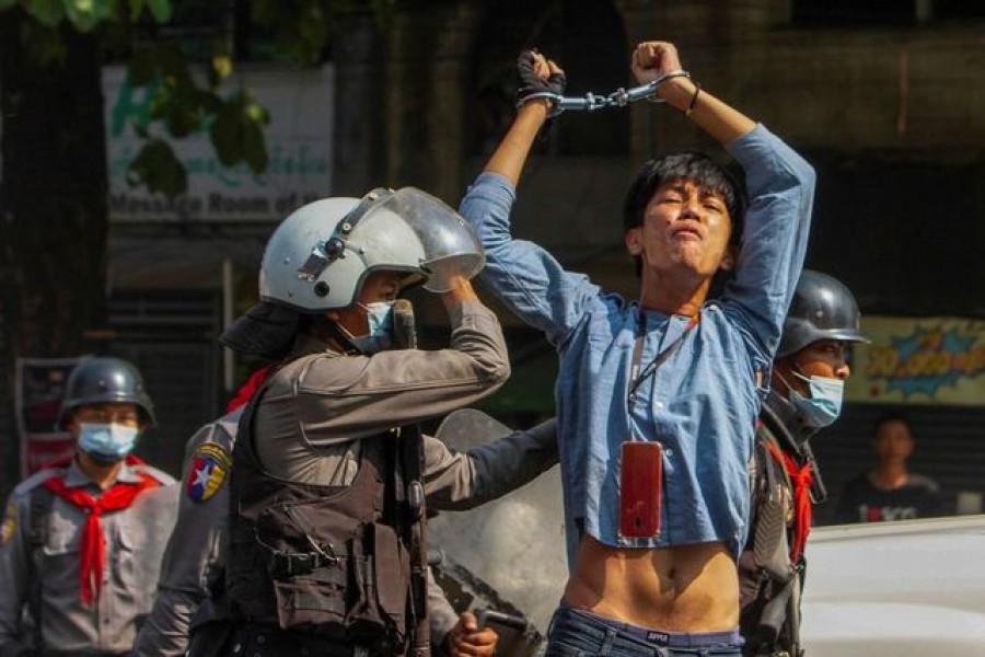 A pro-democracy protester is detained by riot police officers during a rally against the military coup in Yangon, Myanmar, February 27, 2021 — REUTERS/Stringer