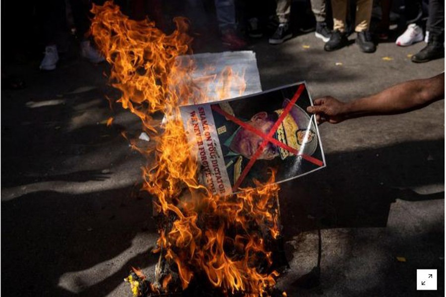 FILE PHOTO: A Myanmar citizen living in India burns a poster of Myanmar's army chief Senior General Min Aung Hlaing with his face crossed out, during a protest organised by Chin Refugee Committee, against the military coup in Myanmar, in New Delhi, India, March 3, 2021. REUTERS/Danish Siddiqui