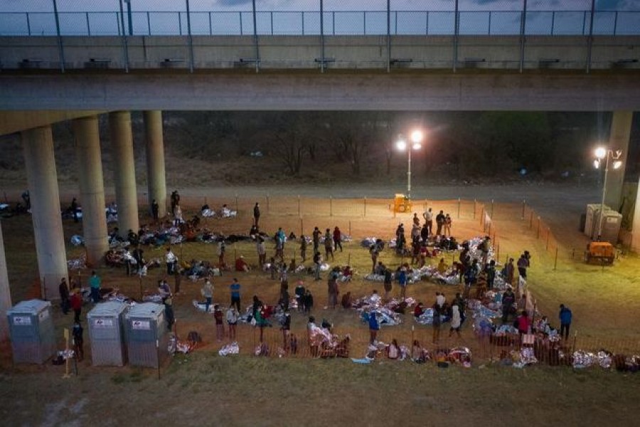 Asylum seeking migrant families and unaccompanied minors from Central America take refuge in a makeshift U.S. Customs and Border Protection processing center under the Anzalduas International Bridge after crossing the Rio Grande river into the United States from Mexico in Granjeno, Texas, U.S., March 12, 2021. REUTERS/Adrees Latif