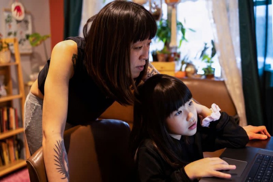 Stefany Stuber, 40, a Korean-American who speaks with her daughter Olivia Metzler, 7, about recent attacks on Asian Americans, shops for clothes for her daughter on the computer in Philadelphia, Pennsylvania, US on March 24, 2021 — Reuters photo